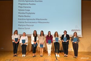 Osoby na scenie pozujace po wręczeniu nominacji