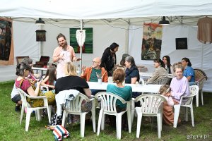 Dorośli siedzący przy stole podczas warsztatów w jednej z festiwalowych stref