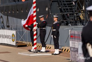 Marynarze wciągają na maszt polską flagę