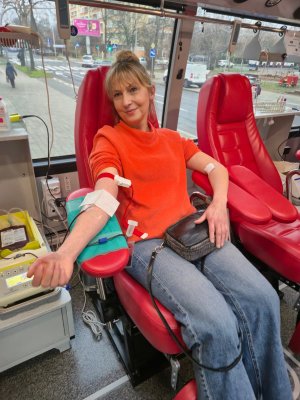 Kobieta w pomarańczowym swetrze oddaje krew