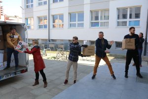 Grupa pięciu osób rozpakowuje przyczepę tworząc tzw. łańcuch rąk. 