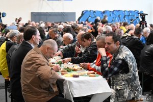 Goście na śniadaniu wielkanocnym siedzą przy stołach