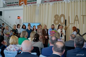 Dyrektorzy gdyńskich szk&oacute;ł gratulujący społeczności Szkoły Podstawowej nr 21 podczas uroczystości jubileuszu 80-lecia plac&oacute;wki