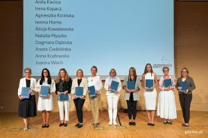 Osoby na scenie pozujace po wręczeniu nominacji