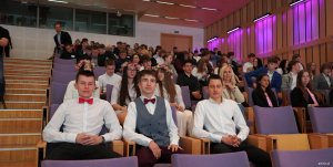 Młodzi chłopcy w białych koszulach i czerwonych muchach na widowni