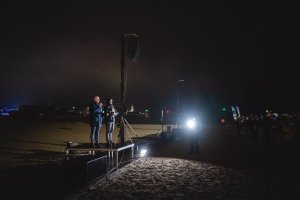 Bartosz Bartoszewicz, wiceprezydent Gdyni ds. jakości życia na zakończeniu pokazu z życzeniami dla gdynian i miasta. Mieszkańcy na pokazie dronów. Fot. Tomasz Kamiński
