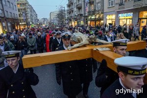 Ludzie idą ulicami miasta w czasie drogi krzyżowej.