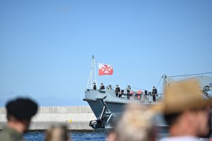 Ludzie fotografują przepływający okręt