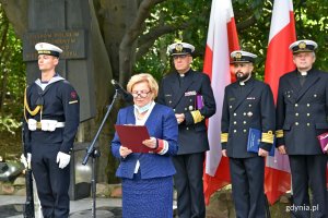 Barbara Pytko, prezes stowarzyszenia Gdyńska Rodzina Katyńska wita gości na obchodach 80. rocznicy zbrodni katyńskiej. W tle marynarze i kapelani Marynarki Wojennej i biało-czerwone flagi // fot. Magdalena Czernek