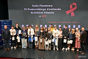 Wsp&oacute;lne zdjęcie laureat&oacute;w nagr&oacute;d z jury, opiekunami i organizatorami podczas gali finałowej Pomorskiego Festiwalu Kr&oacute;tkich Film&oacute;w o HIV 