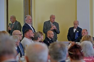 Andrzej Krajniak ze Stowarzyszenia Gdynian Wysiedlonych przemawiający podczas spotkania świątecznego kombatant&oacute;w i os&oacute;b represjonowanych. Obok niego: Waldemar Świto &ndash; prezes gdyńskiego koła Związku Sybirak&oacute;w oraz Krzysztof Jankowski &ndash; pełnomocnik prezydent Gdyni ds. kombatant&oacute;w i os&oacute;b represjonowanych