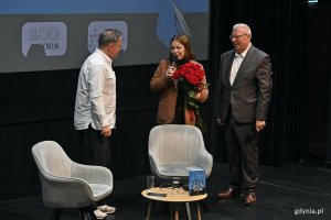 Markos Pagudis &ndash; prezes zarządu Agencji Rozwoju Gdyni i wiceprezydentka Gdyni Oktawia Gorzeńska dziękują i wręczają kwiaty Grzegorzowi Kasdepkemu podczas premiery książki pt. &bdquo;Lufcik&rdquo; w Gdyńskim Centrum Filmowym