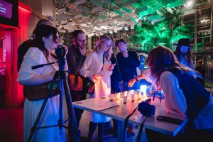 Warsztaty perfumiarskie i uczestnicy, kt&oacute;rzy przygotowywują własne kompozycje zapachowe.