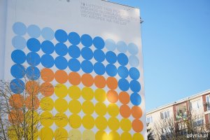 Kolorowe koła na ścianie jednego z blok&oacute;w na Karwinach układające się we wsch&oacute;d słońca nad morzem