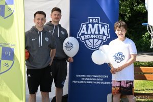 Dwóch mężczyzn i chłopiec z balonami w rękach na stoisku Akademickiego Stowarzyszenia Koszykówki Akademii Marynarki Wojennej Gdynia podczas Gdyńskiego Pikniku Pozarządowego