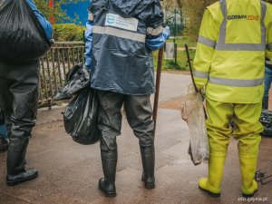 osoby zbierają odpady, niosą worki z odpadami, trwa sprzątanie