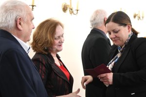 Starsi państwo i kobieta w granatowej marynarce