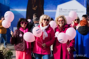 Uczestniczki Marszu Różowej Wstążki z różowymi balonami w rękach przed Teatrem Miejskim w Gdyni 