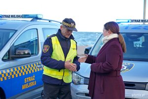 Prezydent Gdyni Aleksandra Kosiorek przekazuje kluczyki do radiowozu jednemu ze strażnik&oacute;w miejskich