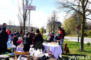 Grupa ludzi przy stołach na zewnątrz