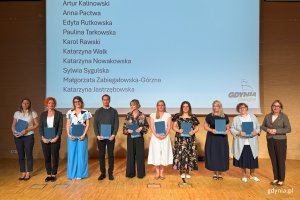 Osoby na scenie pozujace po wręczeniu nominacji
