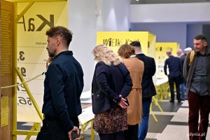 Uczestnicy wernisażu wystawy &bdquo;Gen 100 &ndash; gdyński kod wsp&oacute;lnoty&rdquo; oglądający ekspozycję w Muzeum Emigracji 