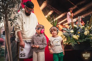 Meżczyzna z dwójką dzieci, na uszach mają słuchawki