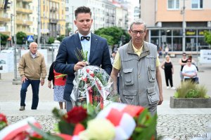 Składanie kwiatów pod pomnikiem