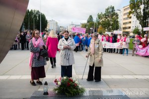 Prezydent Gdyni Aleksandra Kosiorek i Janina Łojba – prezes Stowarzyszenia Amazonek Gdyńskich składające kwiaty pod pomnikiem Polski Morskiej podczas Marszu Różowej Wstążki 