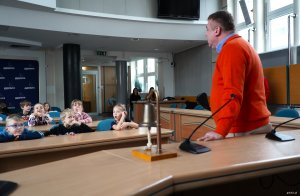 Mężczyna na pomarańczowym swetrze i dzieci