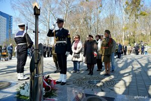 Przedstawiciele stowarzyszenia Gdyńska Rodzina Katyńska z prezes Barbarą Pytko na czele oraz goście z Helu składający kwiaty pod pomnikiem Ofiar Katynia podczas uroczystości z okazji Dnia Pamięci Ofiar Zbrodni Katyńskiej