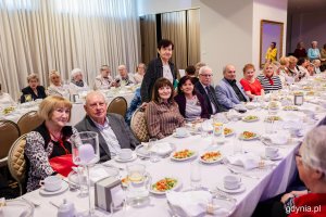 Grupa senior&oacute;w siedzi przy elegancko zastawionym stole