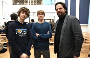 Dw&oacute;ch chłopc&oacute;w i mężczyzna w garniturze z czarną brodą