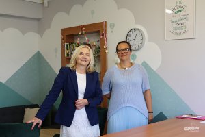 Dwie kobiety patrzące się w obiektyw na tle ścian pomalowanych w niebo balony i góry