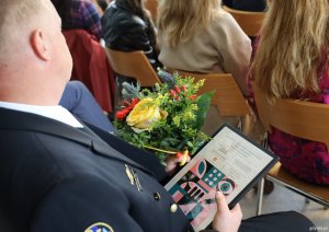 Nagrodzony mł. chorąży marynarki Wojciech Łazarczyk z kwiatami i dyplomem