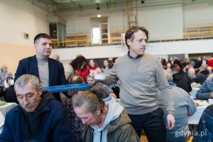 Wiceprezydent Maciej Zielonka i radny miasta Łukasz Piesiewicz roznoszący świąteczne potrawy gościom wigilii dla samotnych i potrzebujących