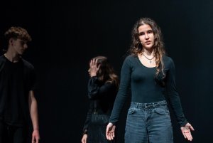 Dwójka aktorów w ciemnych strojach na scenie