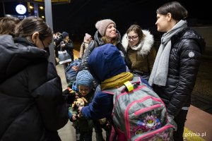 Wiceprezydent Gdyni Katarzyna Gruszecka Spychała rozmawia z uchodźcami z Ukrainy na peronie kolejowym.