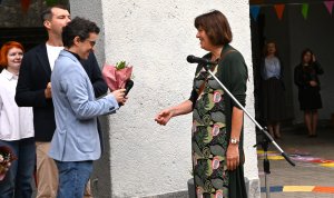 Mężczyzna wręcza kwiaty kobiecie z zielonej sukience