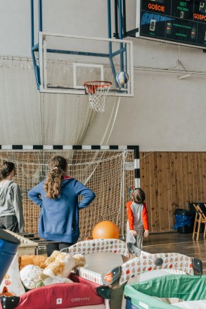 Dzieci grają w koszykówkę obok łóżek na sali gimnastycznej w ZSP nr 3 // fot. Filip Śmigielski