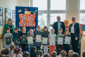 Dzieci i nauczyciele oraz wiceprezydent Michał Guć pozują do wspólnego zdjęcia
