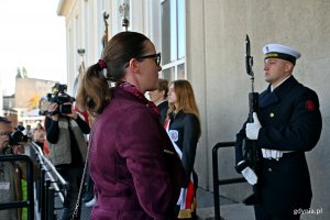 Posłanka Wioleta Tomczak składająca kwiaty pod tablicą pamiątkową, kt&oacute;ra znajduje się na fasadzie Dworca PKP Gdynia Gł&oacute;wna, podczas uroczystości z okazji 87. rocznicy pierwszych wysiedleń Gdynian