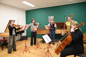 Nauczycielka i uczniowie grają na smyczkach