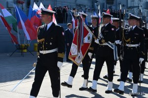 Żołnierze Marynarki Wojennej defilują przed okrętem ORP "Gen. K. Pułaski" podczas powitania ministrów obrony państw Grupy Wyszehradzkiej. Marynarze w drugim rzędzie niosą sztandar // fot. Michał Puszczewicz