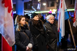 Grupa osób stojących przed pomnikiem