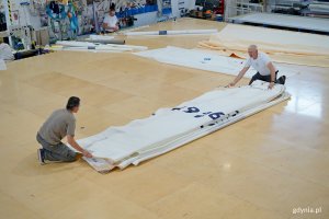 Pracownicy firmy Sail Service składający żagiel stulecia Gdyni 