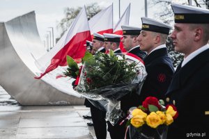 Marynarze z wieńcami i wiązankami kwiatów stojący przy pomniku Polski Morskiej podczas uroczystości z okazji 78. rocznicy zakończenia walk o Gdynię // fot. Kamil Złoch