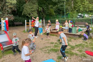 Grupa dzieci 5-letnich z nauczycielką przedszkolną na placu zabaw
