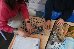 Ręce os&oacute;b układających puzle