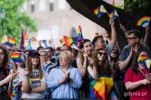 Uczestnicy 11. Tr&oacute;jmiejskiego Marszu R&oacute;wności z flagami i chorągiewkami w rękach 